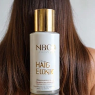 A bottle of 'Hair & Nail Elixir' with a sleek, gold-accented label, showing healthy hair strands and strong nails.